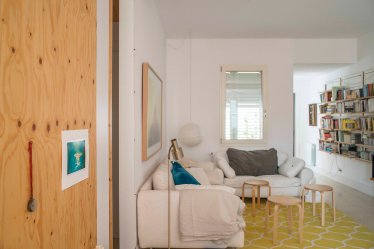 Imagen parcial de un estar donde se ve 2 sofás distribuidos en L. En una de las paredes hay un cuadro